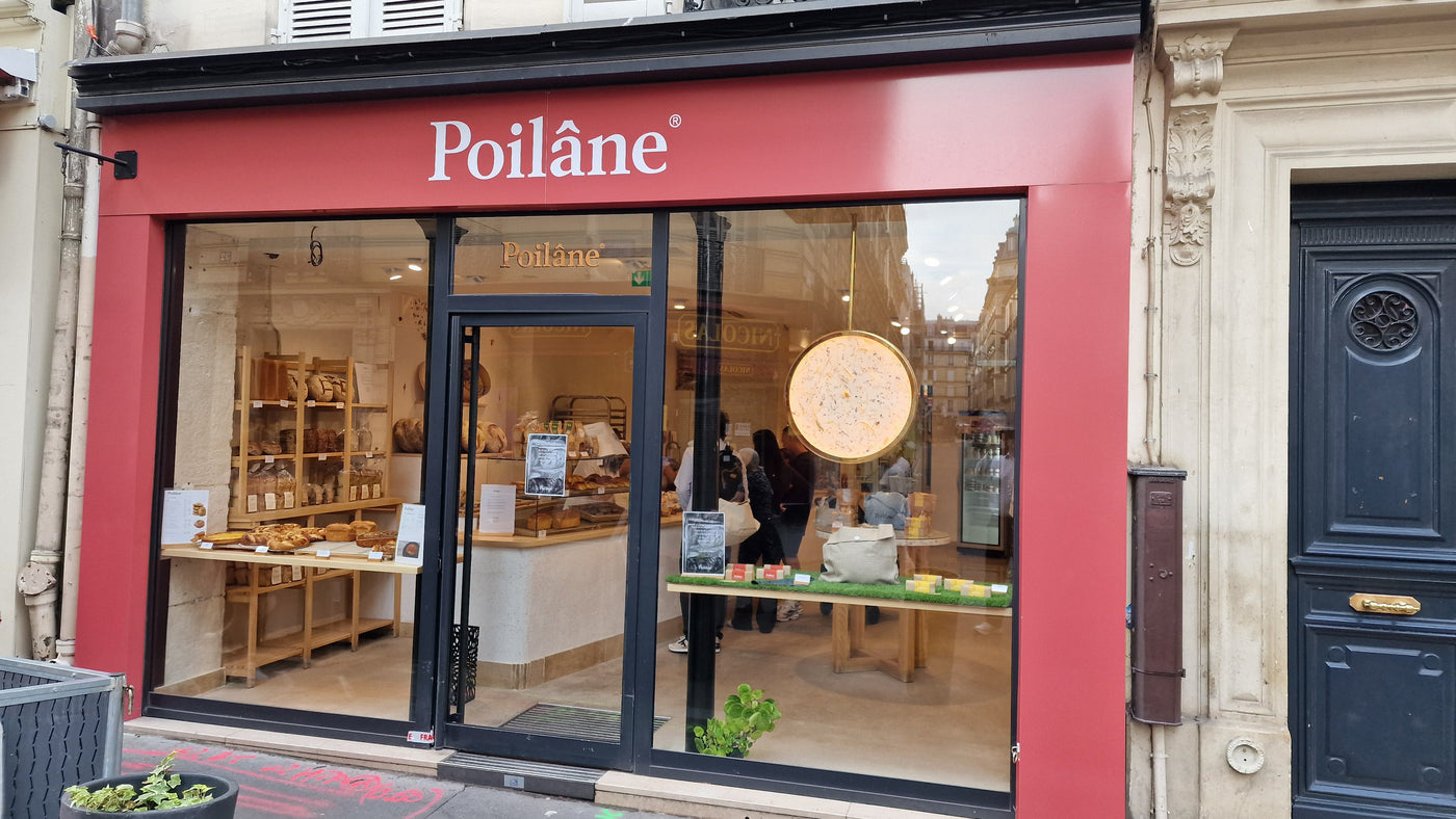 Devanture de la boulangerie Poilâne rue de Lévis avec vitrines de pains et pâtisseries