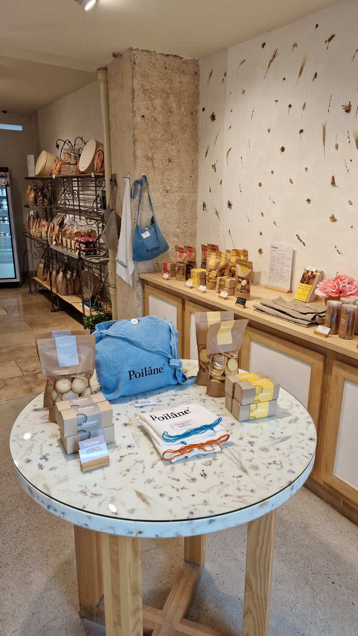 Table et comptoir de la boutique Poilâne rue de Lévis avec sablés, sacs en lin et cadeaux gourmands